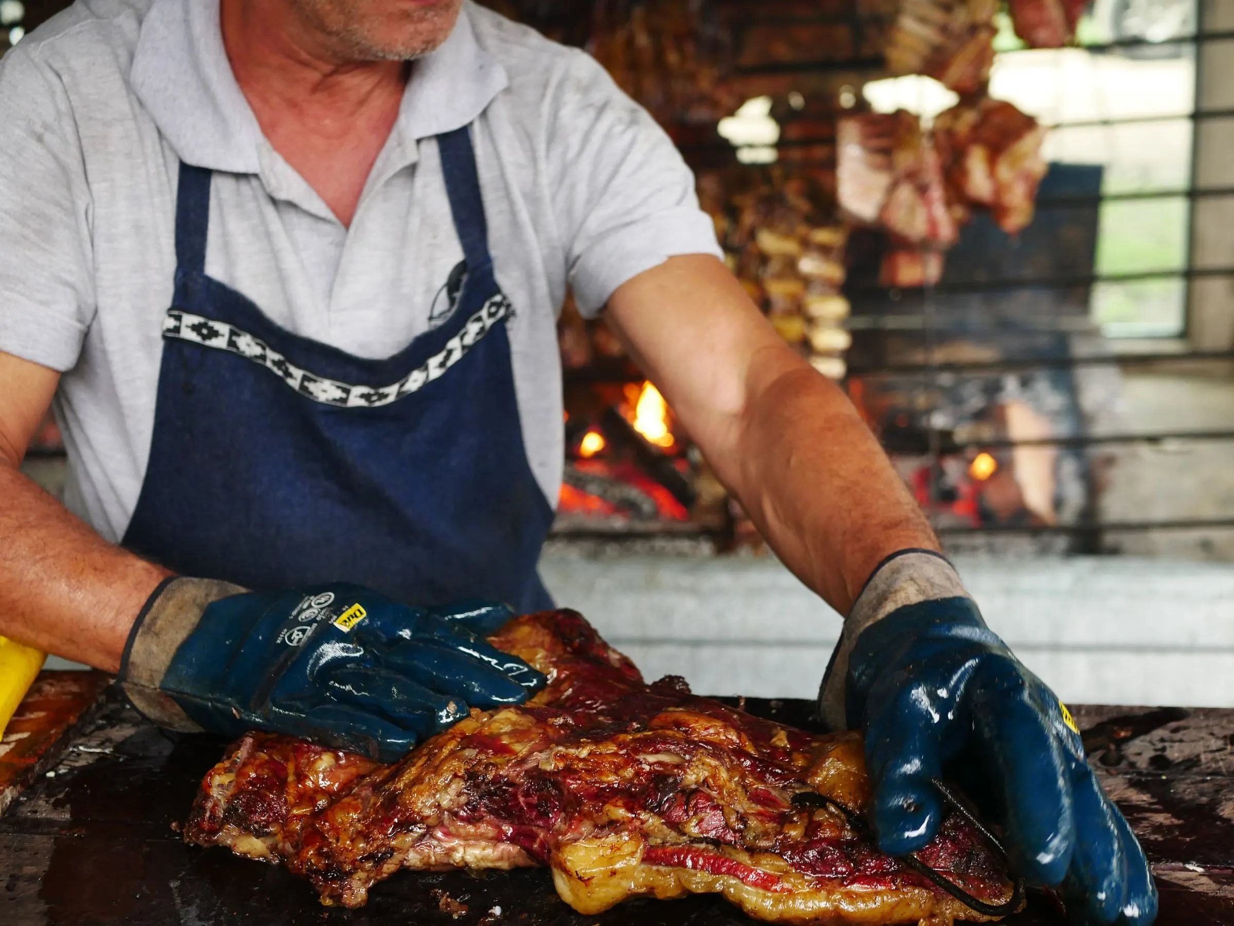 El parrillero del Asador Artebe preparando la carne junto al fuego de leña